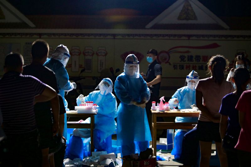 FILE PHOTO: Medical workers attend to people lining up for