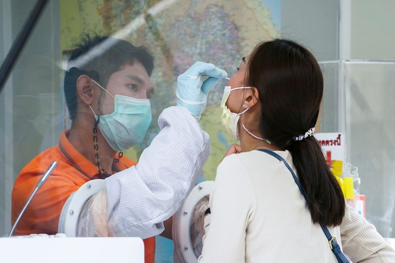 FILE PHOTO: A healthcare worker takes a nasal swab sample