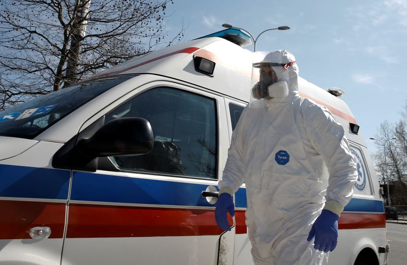 A healthcare worker wearing personal protective equipment (PPE) walks past