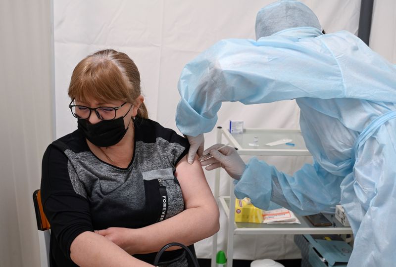 A woman receives a vaccine against the coronavirus disease in