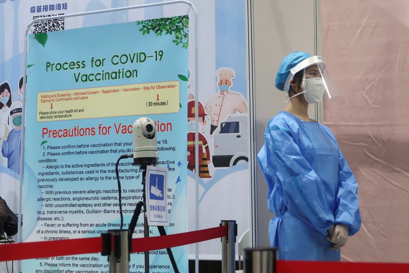 A staff member waits outside a booth where people receive
