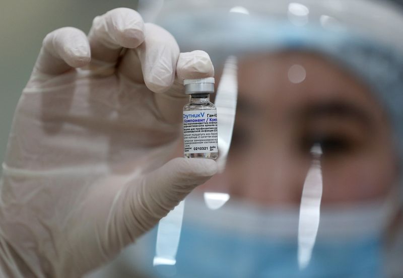FILE PHOTO: A medical worker holds a vial with COVID-19