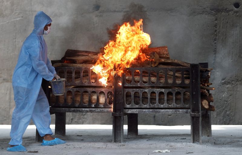FILE PHOTO: Frontline workers prepare a funeral pyre on the