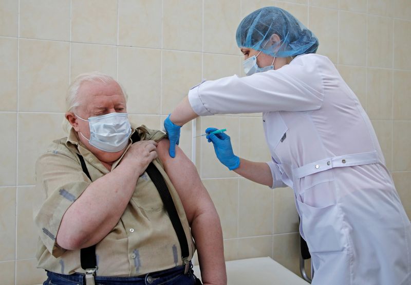A man receives a dose of the EpiVacCorona COVID-19 vaccine