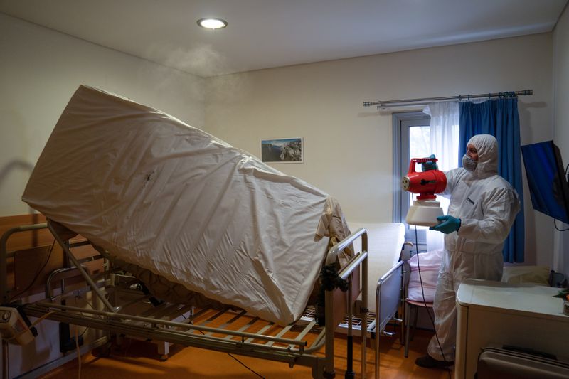 A worker in protective suit disinfects a room in a
