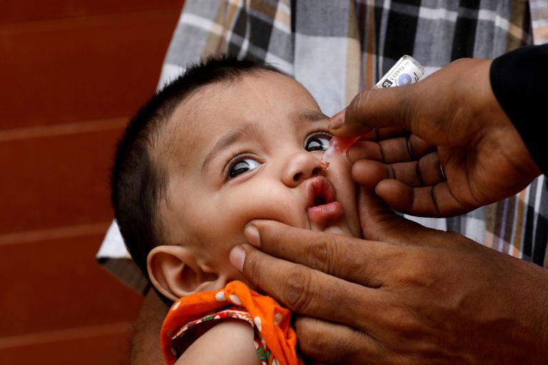 FILE PHOTO: A girl receives polio vaccine drops, during an