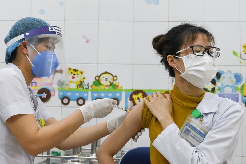 FILE PHOTO: A woman receives a vaccine as Vietnam starts