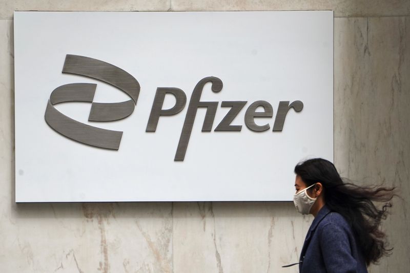 A person walks past a Pfizer logo in New York