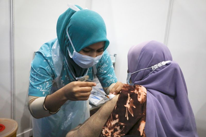 A woman receives a vaccine for the coronavirus disease (COVID-19),