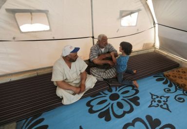 Youssef Ramadan, talks to his son as he sits inside