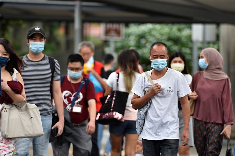 People wearing face masks cross a road amid the coronavirus