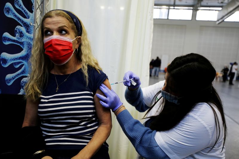 FILE PHOTO: A woman receives a vaccination against the coronavirus