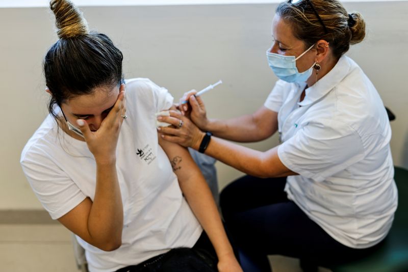 FILE PHOTO: A teenager receives a dose of a vaccine