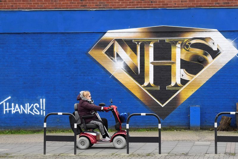 Mural praising the NHS (National Health Service) is seen amidst