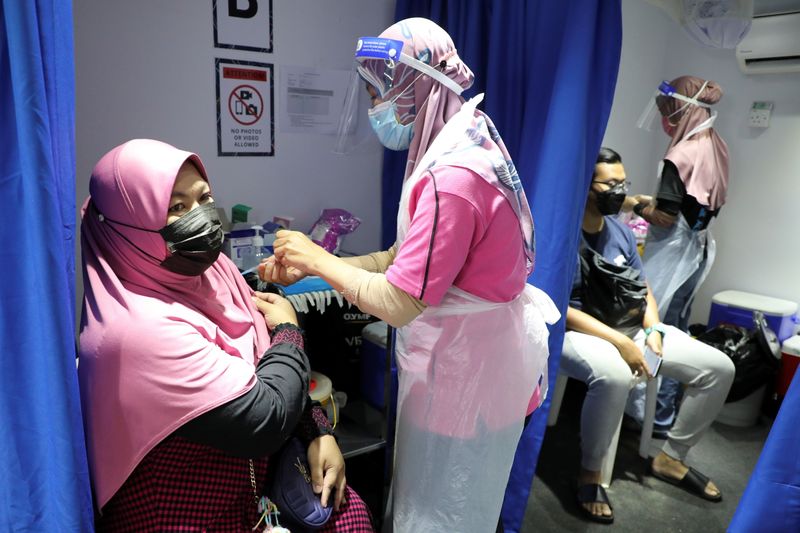 People receive COVID-19 vaccine in a vaccination truck in Kuala
