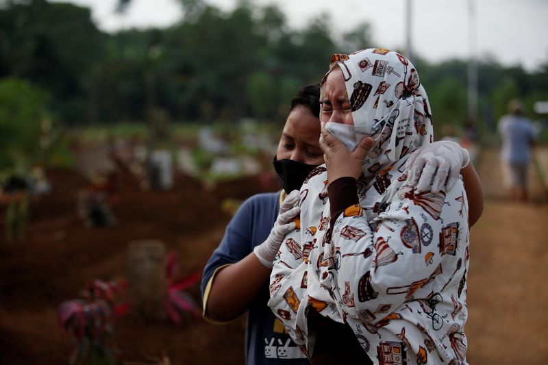 The Wider Image: Volunteer undertakers bear the dead from Indonesian