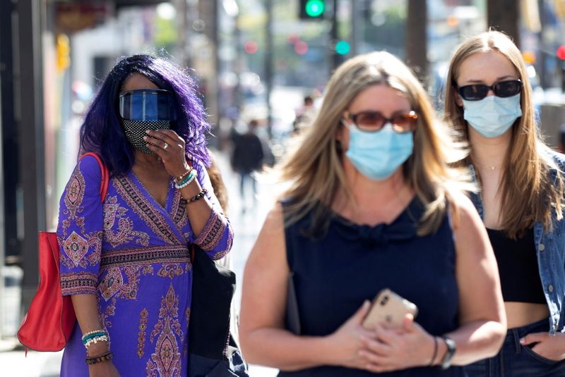 FILE PHOTO: People wearing face protective masks walk on Hollywood