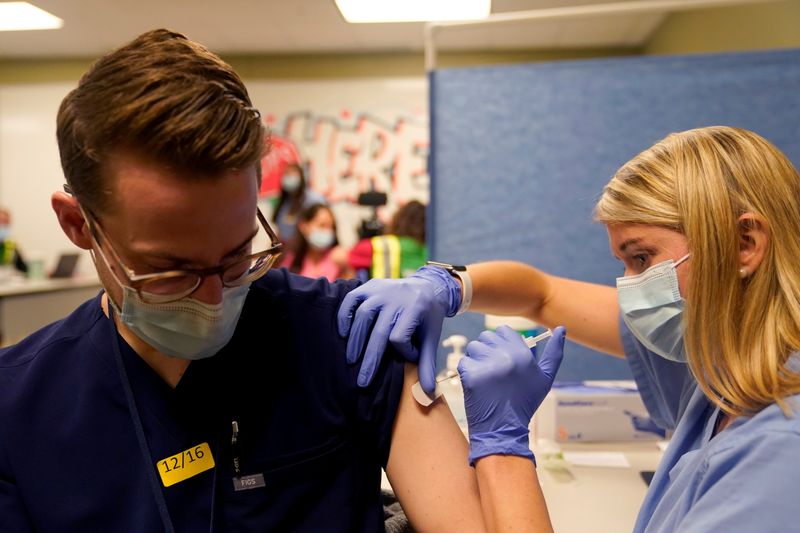 FILE PHOTO: The Pfizer-BioNTech coronavirus disease (COVID-19) vaccines are administered