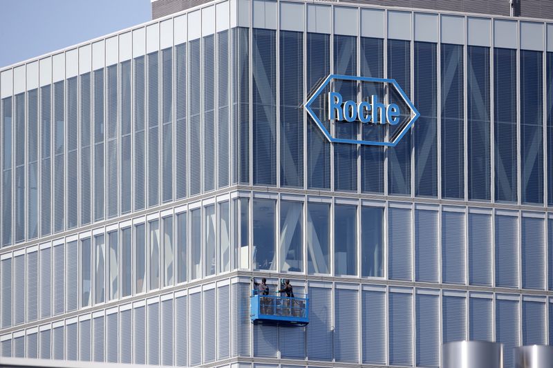 FILE PHOTO: Workers clean windows of a building of Roche