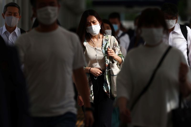 Commuters wearing masks leave a train station during the coronavirus