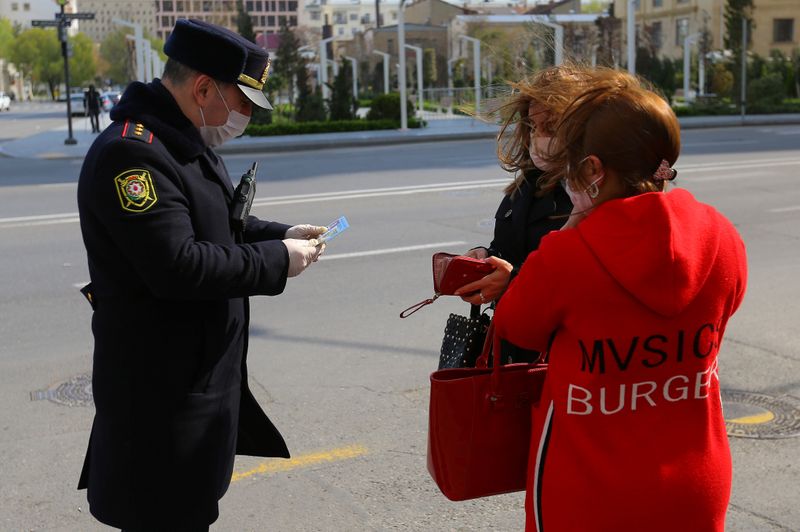 An Azeri law enforcement officer checks documents of women in