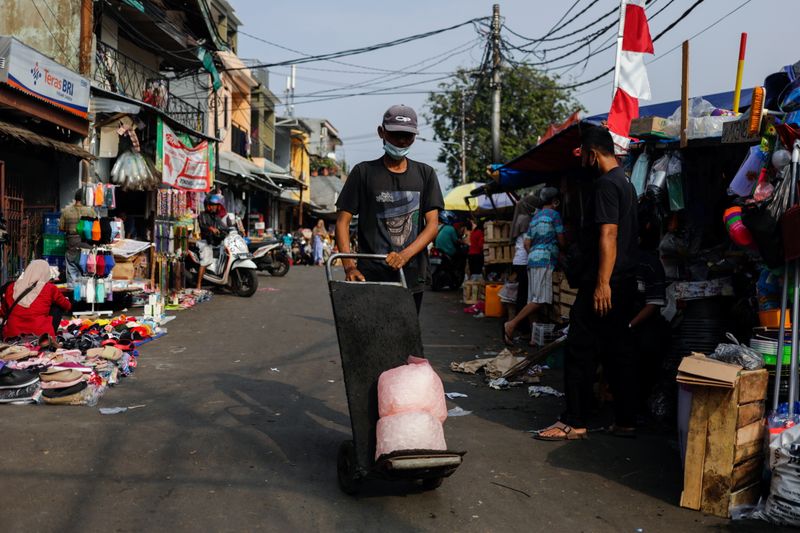 A man wearing a protective mask pushes a trolley at