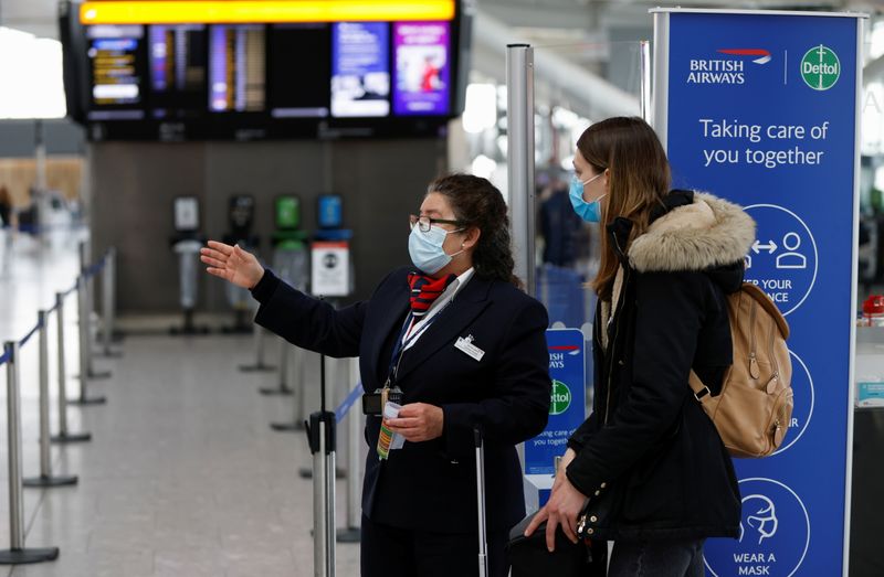 FILE PHOTO: A passenger speaks with a British Airways staff