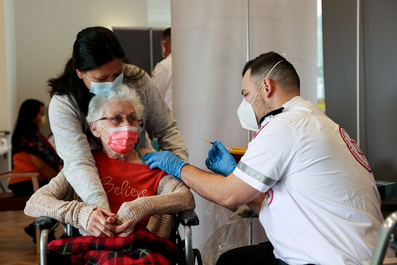 FILE PHOTO: An elderly woman receives a booster shot of