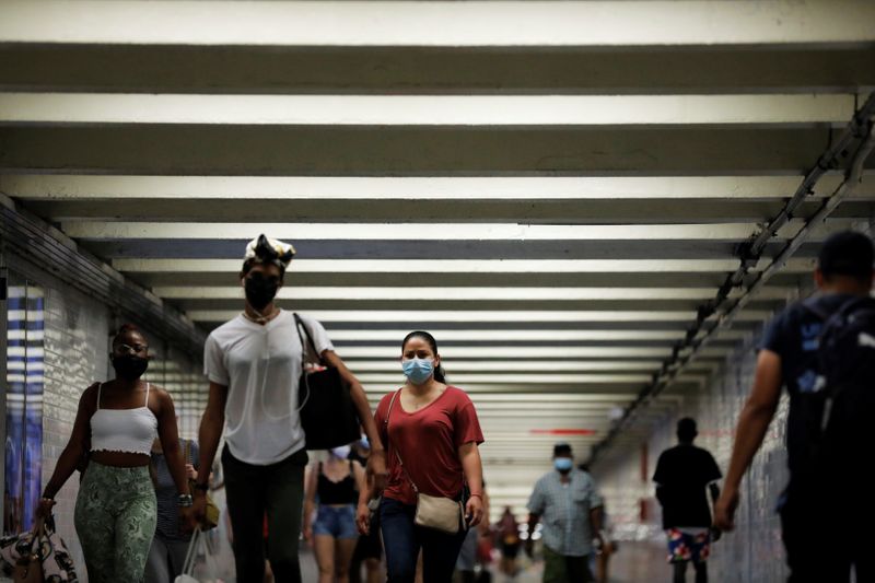 People wear masks as they pass through a pedestrian subway