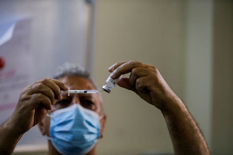 A health worker prepares a vaccine against the coronavirus disease