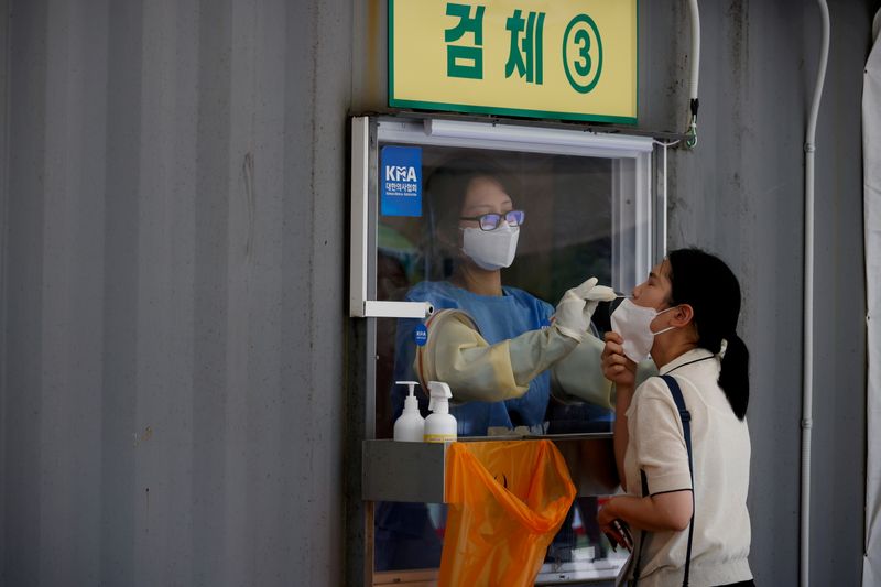 FILE PHOTO: FILE PHOTO: A woman gets a coronavirus disease