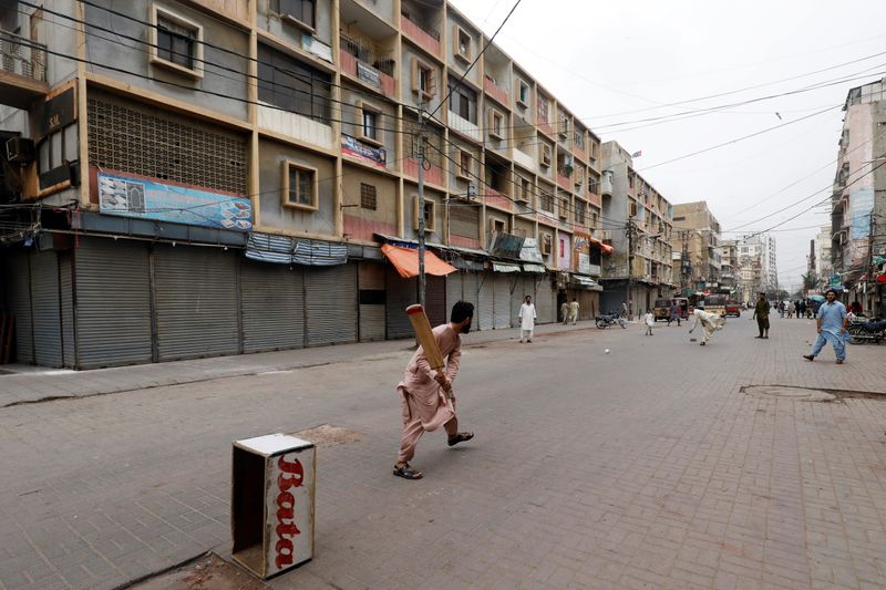 Shopkeepers play cricket along closed market amid the COVID-19 outbreak