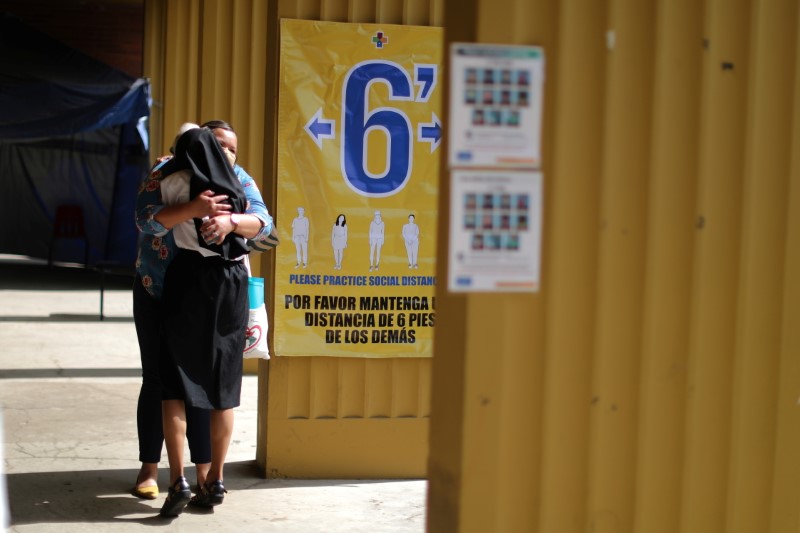 People hug at a COVID-19 vaccination clinic in Los Angeles