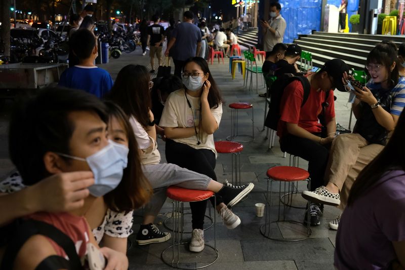 People wait in front of a restaurant, following an outbreak