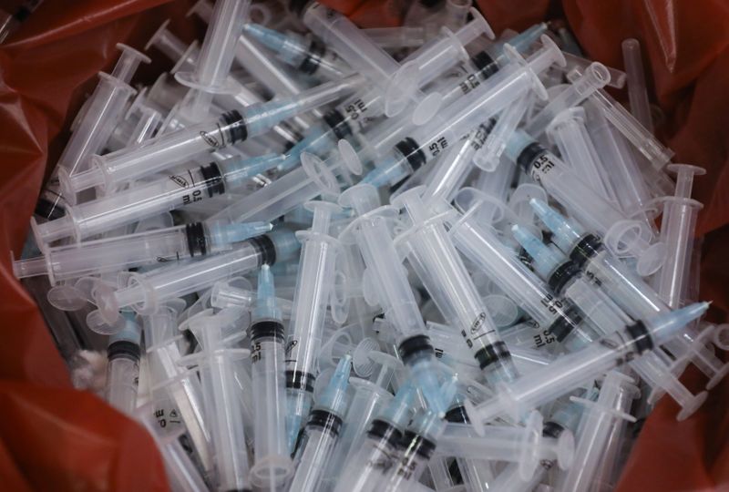 Used syringes lie discarded in a bin after they were