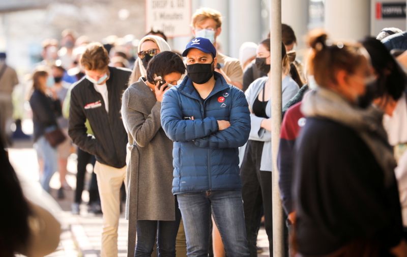 FILE PHOTO: People queue outside a coronavirus disease (COVID-19) vaccination