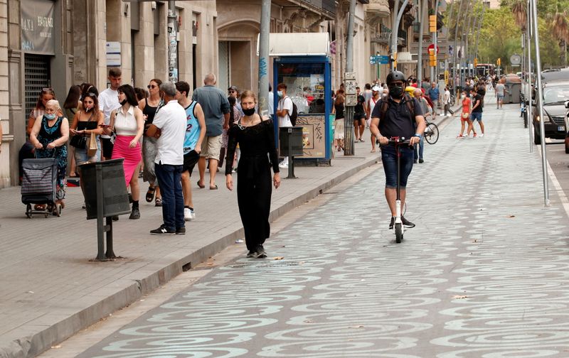 People walk by a pedestrian zone painted in blue at