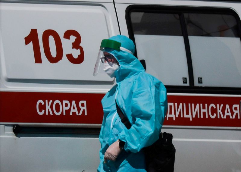 FILE PHOTO: A medical specialist walks by an ambulance outside