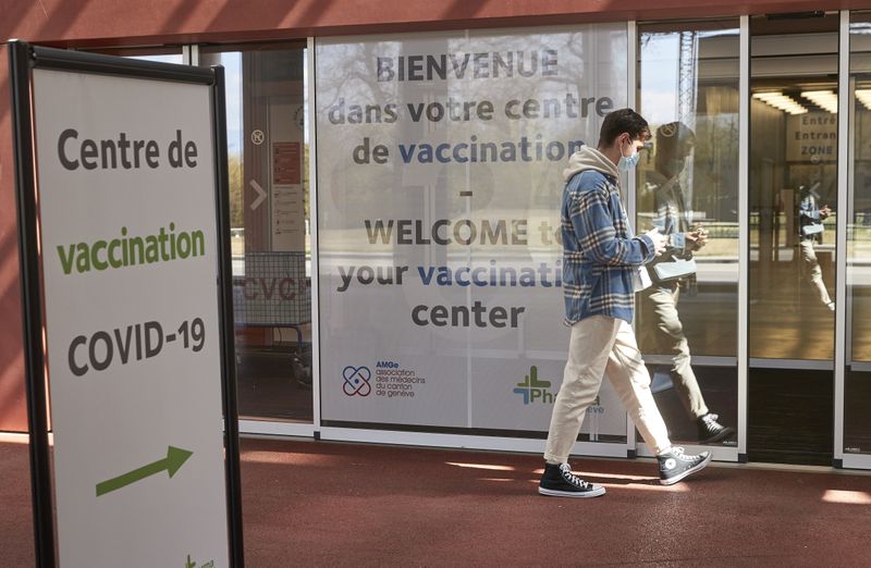A man walks past a sign at a COVID-19 vaccination