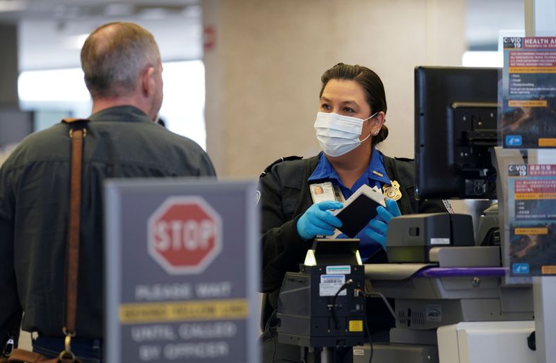 FILE PHOTO: A masked TSA officer at Dulles Airport in