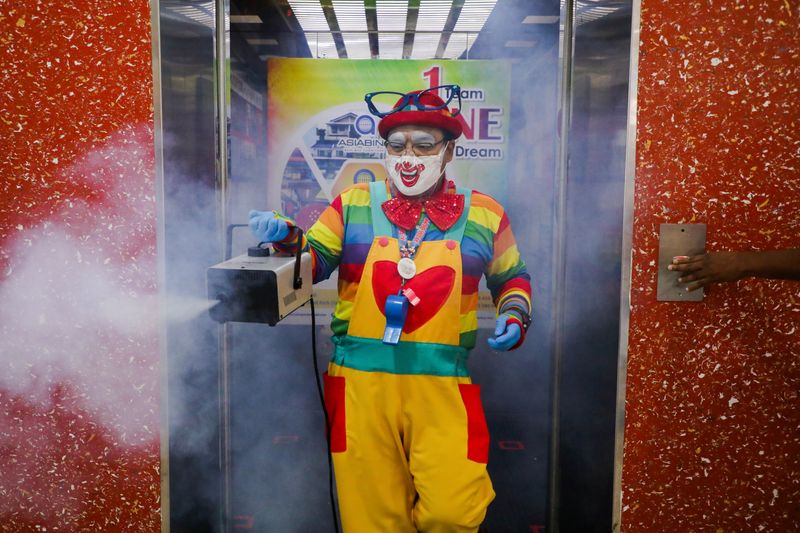 Shaharul Hisam bin Baharuddin, 43, dressed as a clown disinfects