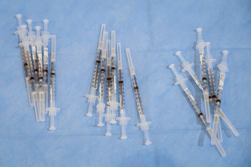 FILE PHOTO: Syringes filled with a doses of Pfizer’s coronavirus