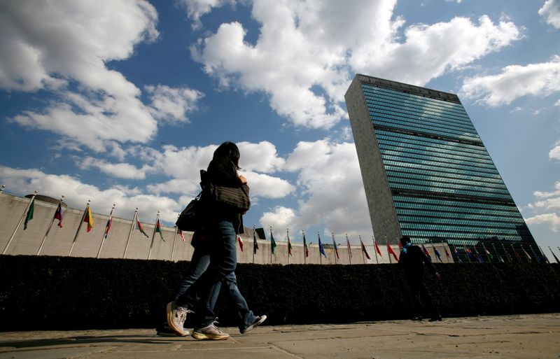 FILE PHOTO: Tourists pass United Nations Headquarters in New York