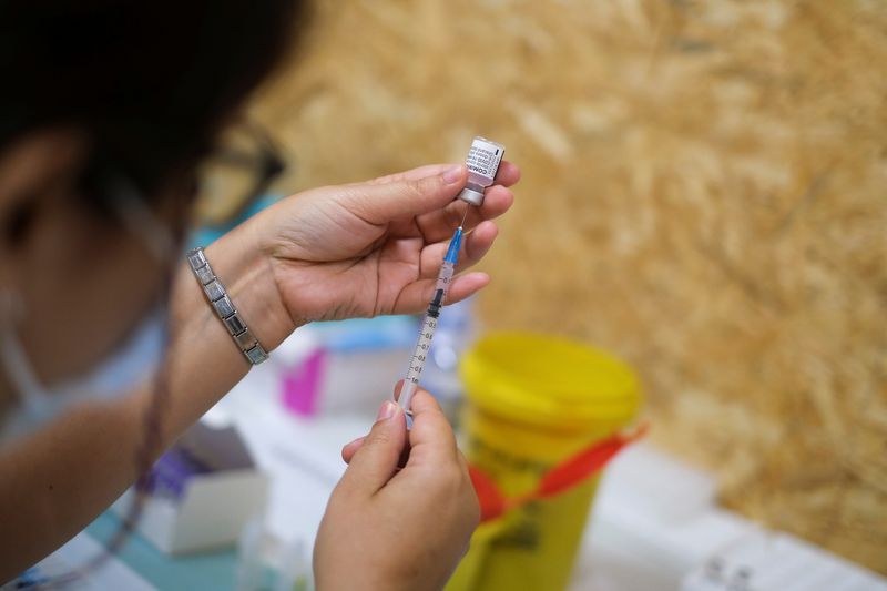 Healthcare worker prepares COVID-19 vaccine at a vaccination centre in