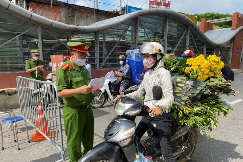 FILE PHOTO: Vietnam police officers inspect commuters at a check