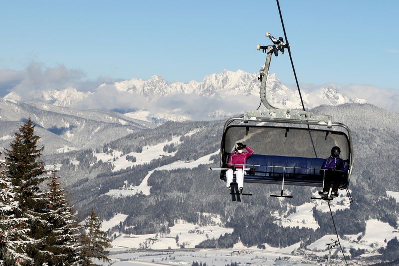 FILE PHOTO: Skiers practise COVID-19 social distancing on a chairlift