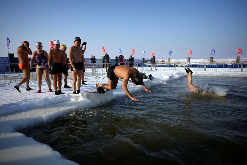 Swimmers jump into a part of the Songhua River, where