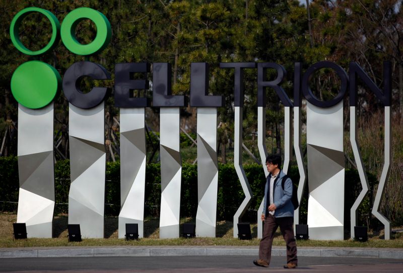 Man walks past a logo of Celltrion Inc in front