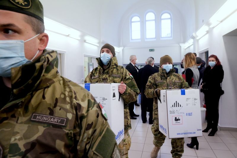 FILE PHOTO: Hungarian soldiers carry the first shipment of Pfizer-BioNTech