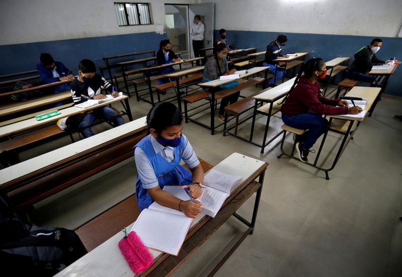 FILE PHOTO: Students wearing protective face masks attend their class